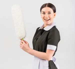 Smiling maid holding a feather duster – professional domestic cleaning service in Surbiton