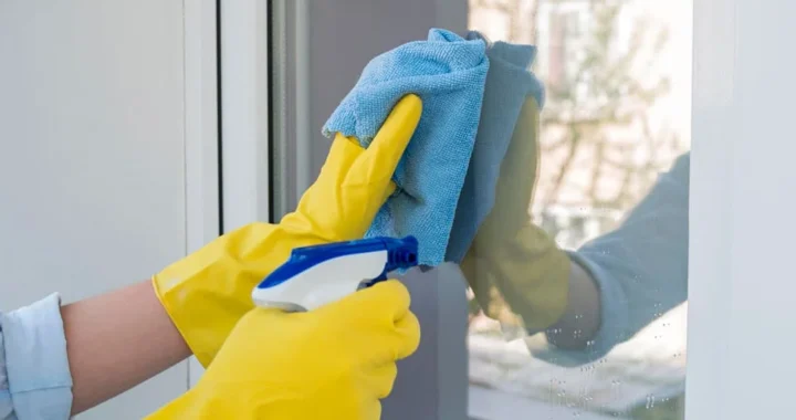 Cleaning house windows with microfiber cloth and spray for streak-free results
